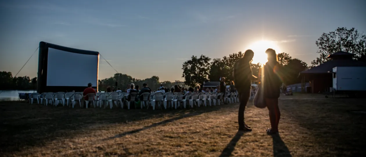 Kinoleinwand und Zuschauende abends am Auesee zum Stadtwerke Sommerkino