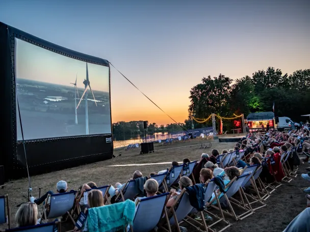 Kinoleinwand und Zuschauende abends am Auesee zum Stadtwerke Sommerkino