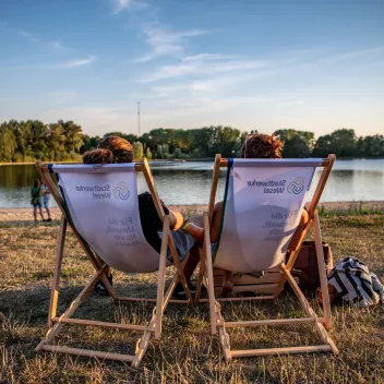 Besucher und Besucherinnen in Stühlen zum Stadtwerke Sommerkino am Auesee