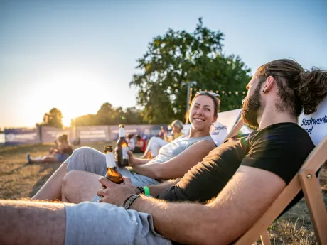Besucher und Besucherinnen in Stühlen zum Stadtwerke Sommerkino am Auesee